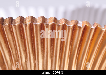 Makroaufnahme von golden Backen Tassen isoliert auf weiss Stockfoto