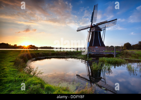 charmanten holländischen Windmühle widerspiegelt im See, bei Sonnenuntergang, Holland Stockfoto