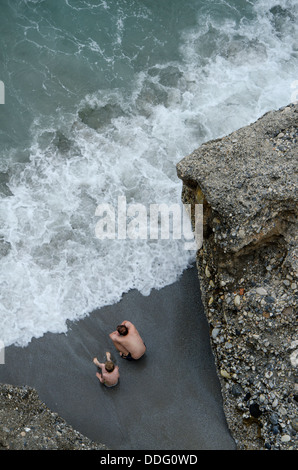 Vater und Sohn am Strand zwischen zwei Klippen in Nerja, Andalusien, Malaga, Spanien. Stockfoto