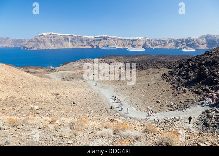 Touristen erkunden die Insel Nea Kameni in Santorini, Griechenland. Stockfoto
