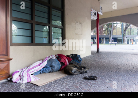 Obdachloser mit Hund schlafen auf Bürgersteig, Annecy, Frankreich Stockfoto