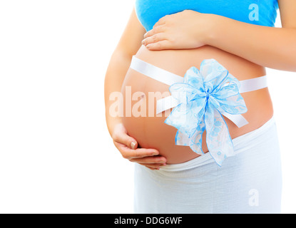 Closeup auf Frau Bauch mit blauen Bogen isoliert auf weißem Hintergrund, es ist ein Junge, das beste Geschenk für die junge Familie, gesunde Schwangerschaft Stockfoto