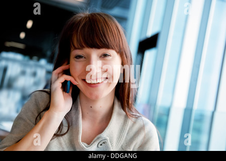 Frau am Handy sprechen und Lächeln, Blick in die Kamera Stockfoto