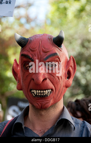 Demonstration gegen jede Einmischung in Syria.A Mann trägt ein Teufel Latex Maske. Stockfoto