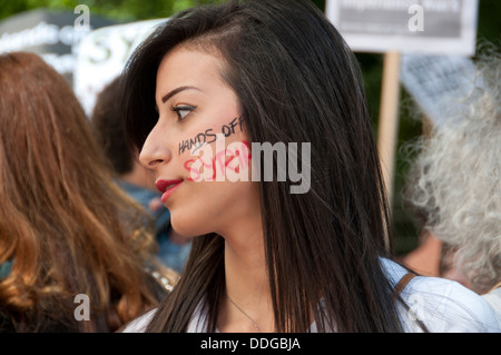 Junge syrische Frau mit Händen aus Syrien gemalt auf die Wange bei Demonstration gegen die Intervention in Syrien Stockfoto