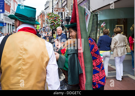 Ein Tourist kommt in einen Leprauchan Anzug festgelegten Straße Entertainer auf der Grafton Street, Dublin, Irland Stockfoto