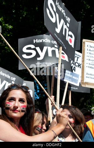 Junge syrische Frauen mit Fahnen gemalt auf ihren Wangen bei Demo gegen die Intervention in Syrien Stockfoto