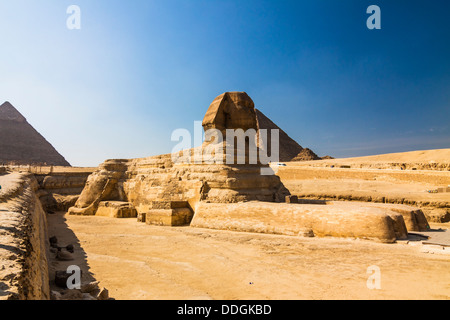 Sphinx von Gizeh mit großen Pyramide im Hintergrund. Ägypten Stockfoto
