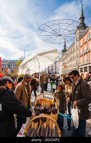 Familie kaufen Barquillos traditionelle Wafer Süßigkeiten auf dem Weihnachtsmarkt in Plaza Mayor, Madrid, Spanien Stockfoto