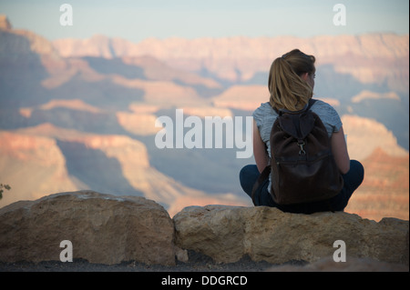 Junge Frau sitzt in Grand Canyon Stockfoto