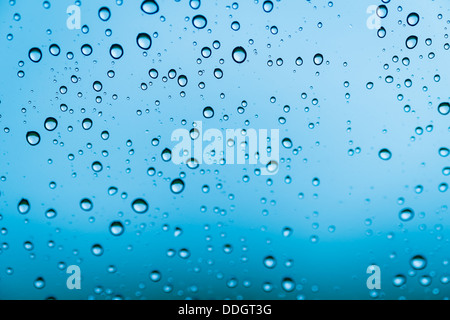 Hintergrund Tropfen Wasser auf blau Glasfarbe Stockfoto