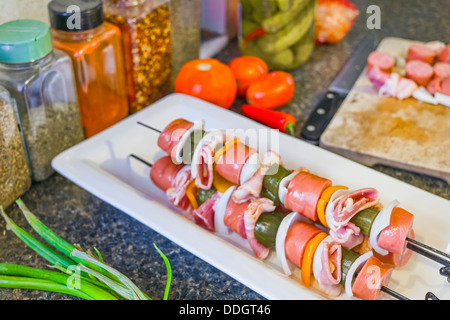 Wurstscheiben mit Gemüse auf ein Tablett in einer Küche, fertig gegrillt wird aufgespießt Stockfoto