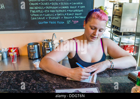 Hipster Mädchen in ihren Zwanzigern, arbeitet an Eisdiele und Piercings und bunten Haaren. Stockfoto