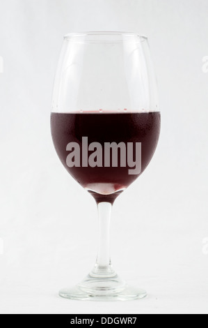 Glas Rot, rose Wein halb voll in ein Glas Wein Stamm mit einem isolierten weißen Hintergrund mit Kondensation auf dem Glas Wein. Stockfoto