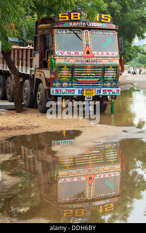 Indien Spedition LKW mit Reflektion in einer Pfütze. Puttaperthi, Andhra Pradesh, Indien Stockfoto