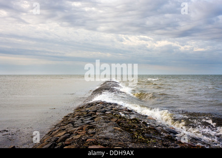 Wellen brechen auf einer Mole im Meer Stockfoto