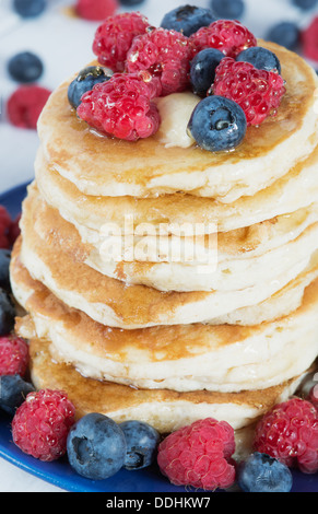 Stapel von altmodischen Pfannkuchen mit Himbeeren, Heidelbeeren und Honig Stockfoto