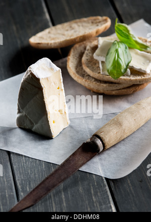 Brie Käse und Toast auf schwarzem rustikalen hölzernen Hintergrund Stockfoto