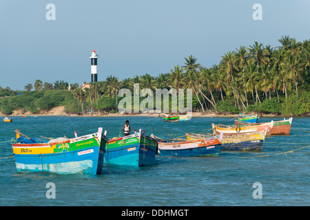 Bunte Fischerboote und Palmen, Leuchtturm am Rücken Stockfoto