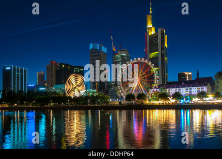 Main-Volksfest mit Fahrgeschäften und Riesenrad vor der Frankfurter Skyline vom Südufer des Mains Stockfoto