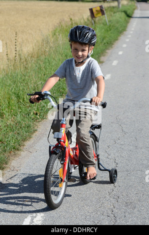 Junge mit dem Fahrrad mit Stützrädern Stockfoto