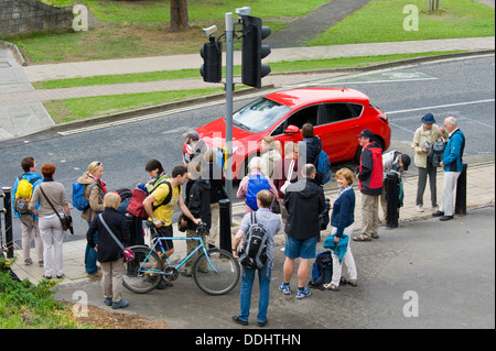 Touristen in offiziellen Reisegruppe warten, überqueren die Straße an der Ampel auf Straße in der Stadt York North Yorkshire England UK Stockfoto