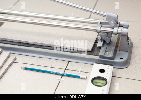 Kleinen Fliesenschneider mit der Verlegung von Fliesen, Bleistift und Niveaurohr Stockfoto