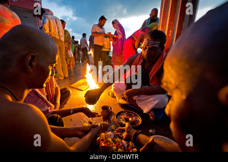 Hindupriester mit Pilgern während ein Feuerritual am Ghat Agni Theertham Stockfoto