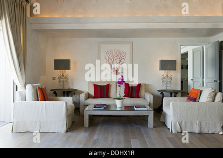Neutrale farbige dreiteilige Suite in luftige Wohnzimmer mit Holzboden und hellen Kissen Stockfoto