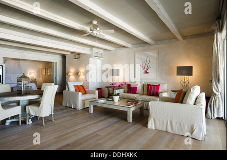 Neutrale Farben drei Stück Suite in luftige Wohnzimmer mit Holzboden, Deckenventilator und Balkendecke Stockfoto