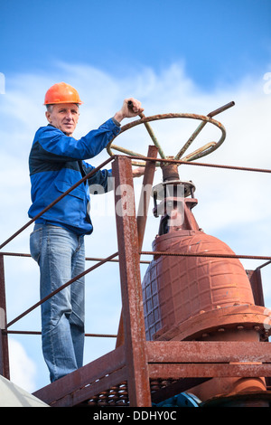 Ältere Arbeiter drehen riesige Nadelverschluss werkseitig Stockfoto