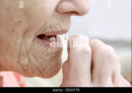 Ältere Frau, die Einnahme einer Tablets Simvastatin (Statine) Medikamente, die die Menge an Cholesterin & Triglyceride im Körper reduziert Stockfoto