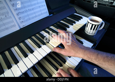 Zwei manuelle elektrische Tastatur (und Kaffee) zu spielen. Stockfoto