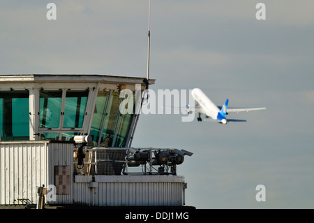 Old Elmdon Air Traffic Control Tower mit einer Thomas Cook Boeing 757 im Hintergrund abheben Stockfoto