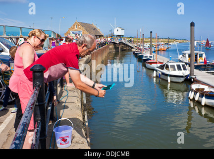 Urlaubern für Krebse angeln oder Verdrehungen im Hafen von Brunnen neben das Meer North Norfolk Küste England UK GB EU Europa Stockfoto