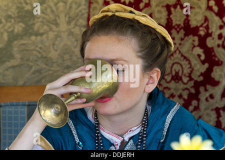 Attraktive junge Frau im Renaissance-Kostüm, trinken aus einer Messing-Schiff auf dem Französisch-Festival in Santa Barbara, Kalifornien Stockfoto