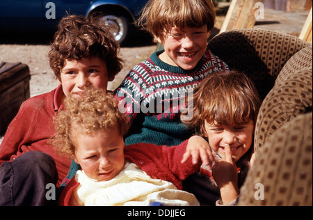 Brüder und Schwesternjungen Mädchen spielen draußen auf einem alten gepolsterten Stuhl Norwich, Norfolk, England Großbritannien England in den 1970er Jahren 1973 KATHY DEWITT Stockfoto