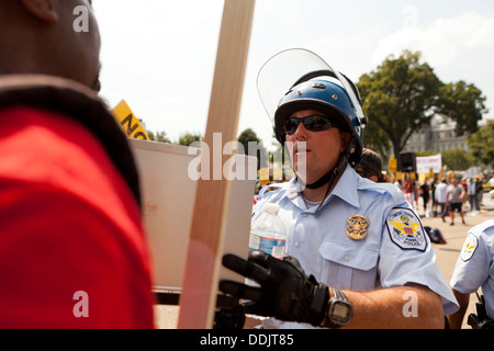 Polizist mit Demonstranten bei einer Kundgebung Stockfoto