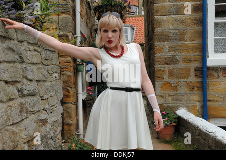 Eine junge Frau, die ein weißes Sara Belted Skater Kleid Modellierung Stockfoto