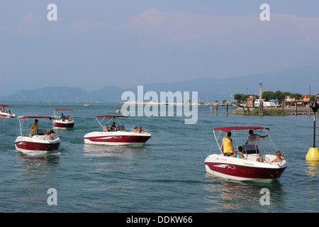 Kleine Boote verlassen am Gardasee und in den Fluss Mincio wie es den See in Peschiera Del Garda in Italien verlässt Stockfoto