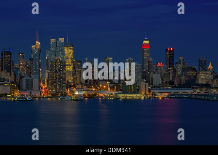 Die Skyline von New York City während der blauen Stunde nach Sonnenuntergang. Das Empire State Building Sport die roten, weißen und blauen Farben. Stockfoto