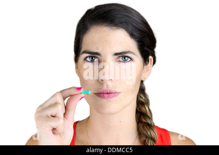 Eine junge Frau mit der Pille in der Hand gegen weiß Stockfoto