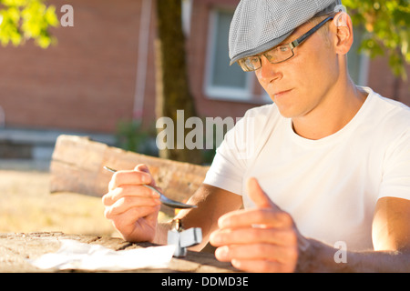 Kaukasische mittleren Alters Drogenkonsumenten eine intravenöse Injektion eine Dosis Heroin vorbereiten Stockfoto