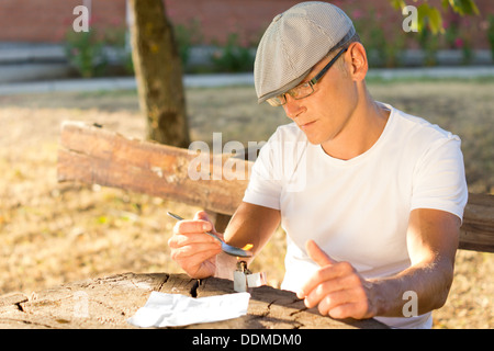 Deprimiert kaukasischen Mann mittleren Alters Vorbereitung einer Medikamentendosis erzielen hohe im freien Stockfoto