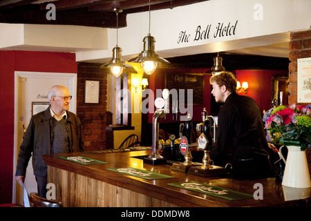 Ein Mann an der Bar im Bell Hotel, einem Gasthof aus dem 16. Jahrhundert, Clare, dienend Suffolk East Anglia UK Stockfoto