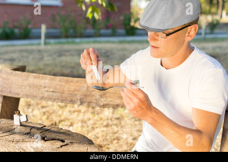 Kaukasischen Mann mittleren Alters süchtig lösliche Crack-Kokain eine Spritze einfüllen Stockfoto