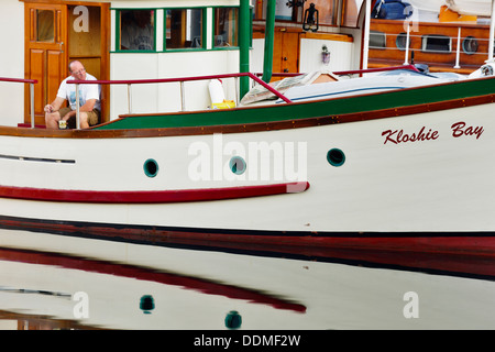 Der Mensch genießen Kaffee und Zigarre auf seine klassische hölzerne Boot-Victoria, British Columbia, Kanada. Stockfoto