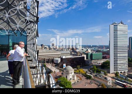 Birmingham, Vereinigtes Königreich. 4. September 2013. Blick auf die Birmingham Skyline mit Leuten auf der oberen Dachterrasse von der Library of Birmingham, die am 3. September 2013 von Malala Yousafzai, die Teenager Schuss in den Kopf in Pakistan durch die Taliban für Frauenrechte eintreten offiziell eröffnet wurde. Die Bibliothek kostet £189m und beherbergt rund 1 Million Bücher. Es hat mehr als 200 öffentlich zugängliche Computer, Theater, eine Galerie und Musik Ausstellungsräume über 9 Etagen. Diese Dachgarten wurde aus den Trümmern der Konstruktion gemacht und hat eine Wildblumenwiese. Bildnachweis: eye35/Alamy Live-Nachrichten Stockfoto