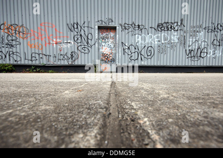 Ein Industriegebäude fällt in Graffiti-Tags, die einen Hauch von Verfall und Vernachlässigung zu verlassen. Stockfoto