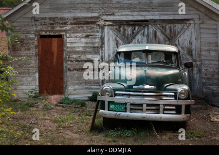 Alte und verlassene Chevrolet Pick-up Truck, parkten außerhalb einer heruntergekommenen Garage, Colorado, USA Stockfoto